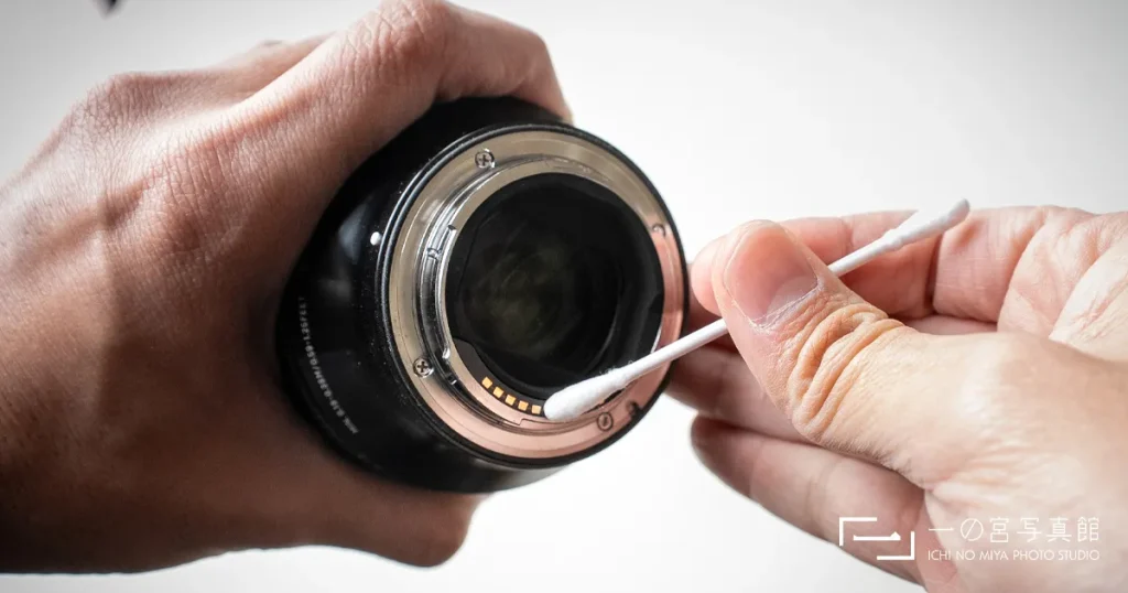 一の宮写真館のカメラマンがソニーのミラーレンズ接点を綿棒で清掃する様子
