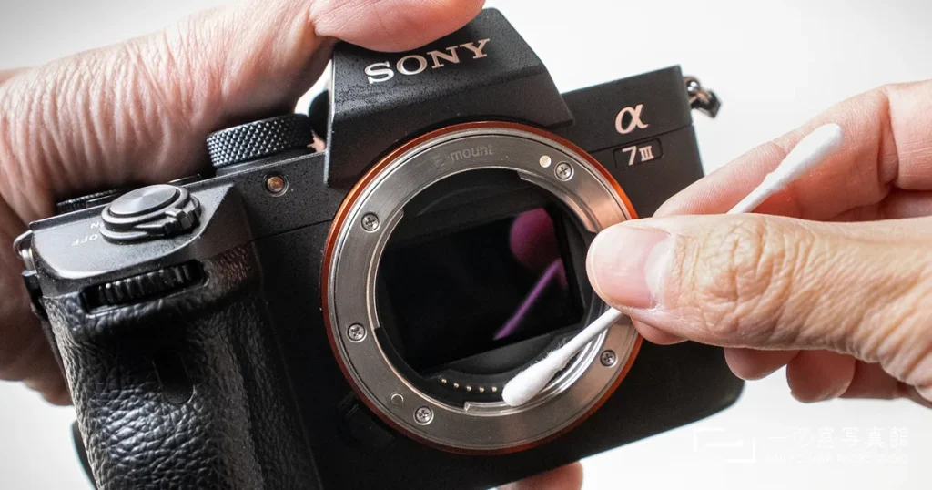 一の宮写真館のカメラマンがソニーのミラーレスカメラA73のボディ接点を綿棒で清掃する様子