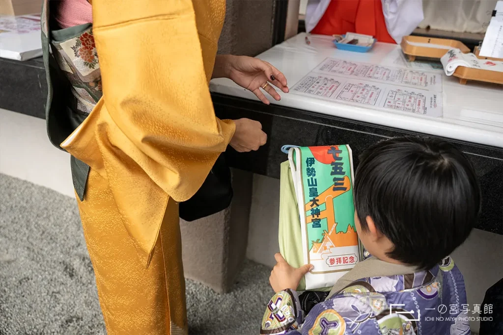 横浜市西区にある伊勢山皇大神宮の受付で七五三のお土産をもらう子供