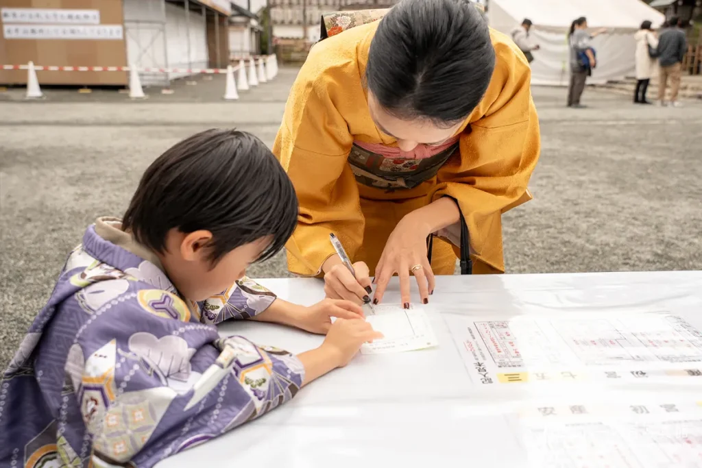横浜市西区にある伊勢山皇大神宮でご祈祷の受付をする七五三の親子